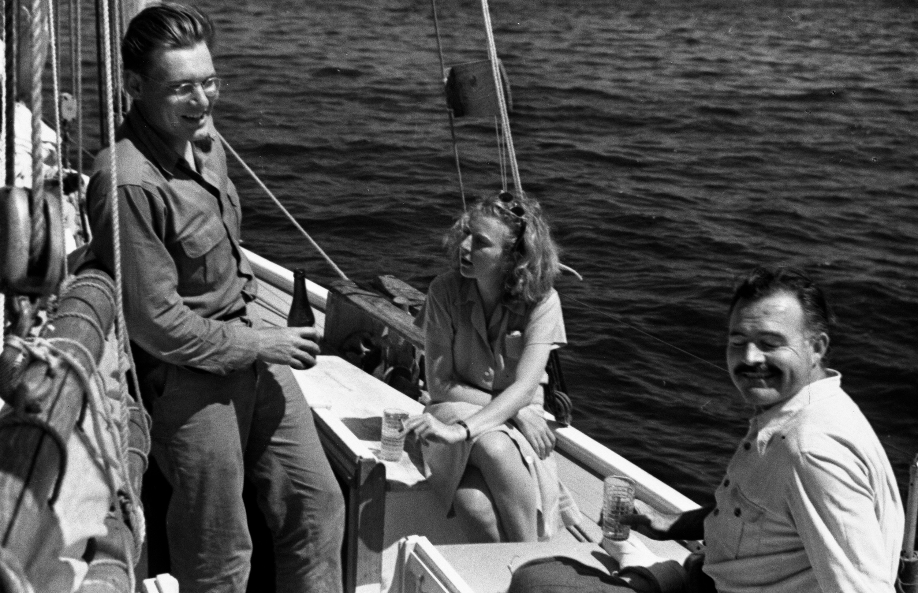 Leicester Hemingway, Martha Gellhorn, and Ernest Hemingway relaxing on Leicester's sailboat, Havana, 1939.