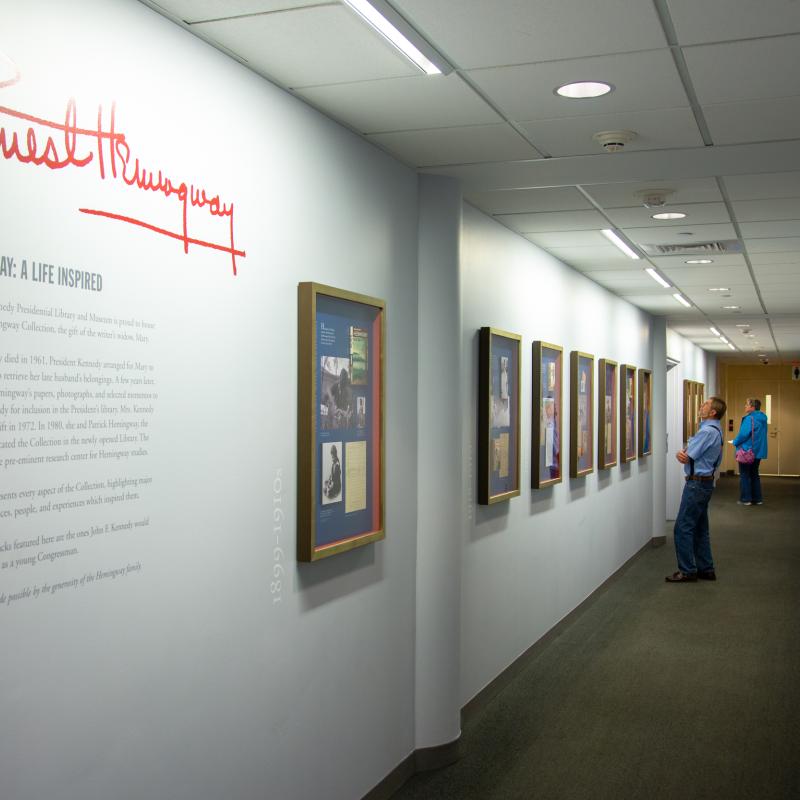 Museum visitors examine the Hemingway: A Life Inspired exhibit.