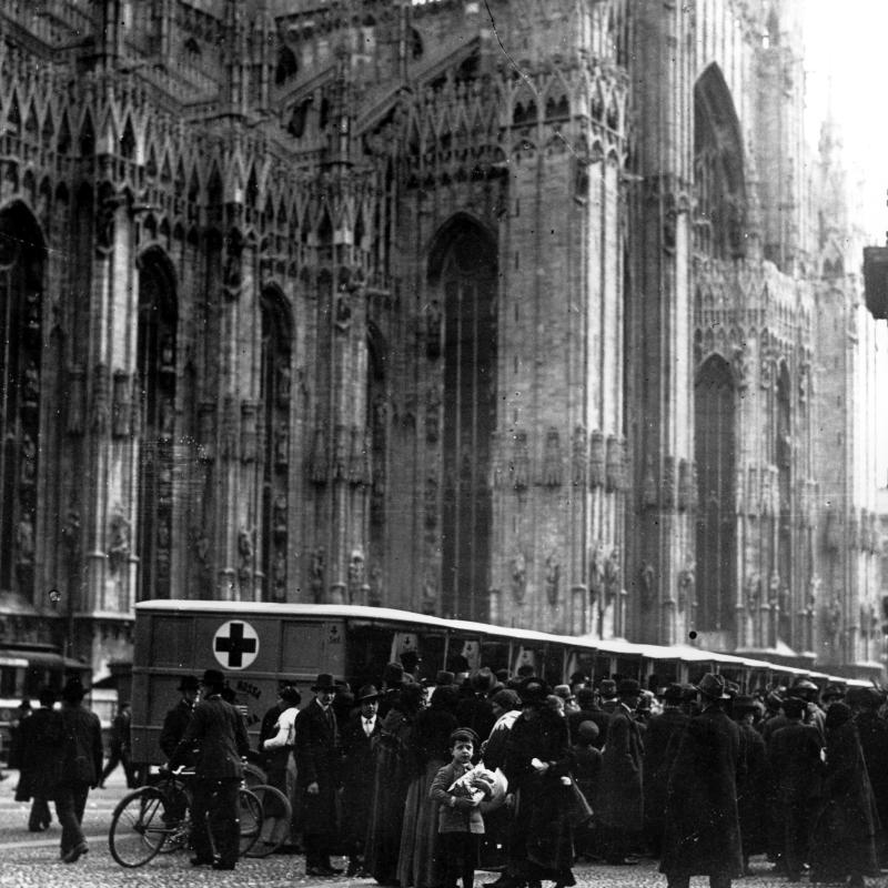 A black and white photograph of Red Cross ambulances parked at the Duomo di Milano, Milan, Italy, during World War 1.  